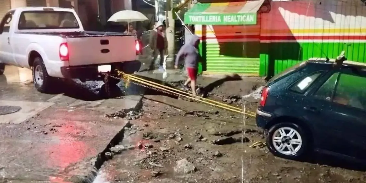 Vehículo atrapado en socavón tras lluvias derriba poste en Tlalancaleca, Puebla